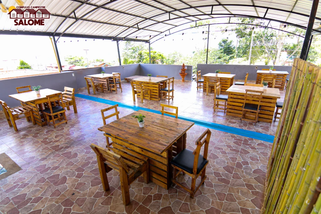 Comedor exterior rústico de madera en Complejo Campestre Salomé, ideal para alojamiento en Lago Calima.