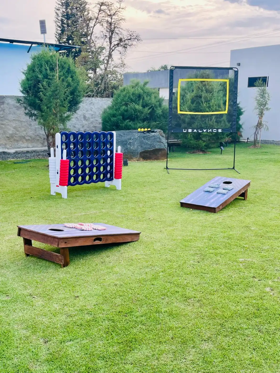 Juegos al aire libre en el jardín de una casa campestre en Lago Calima: Connect Four, cornhole y red de práctica.