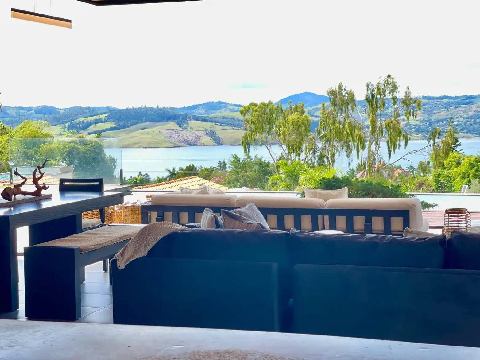 Terraza moderna de casa campestre con vista panorámica al Lago Calima y montañas verdes.