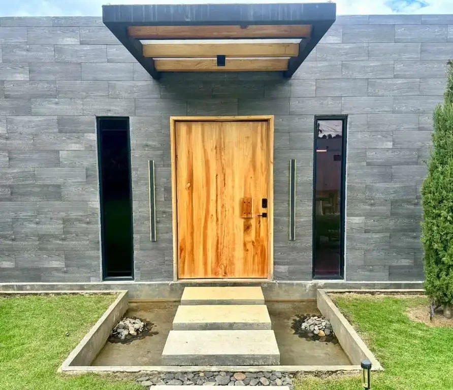 Finca campestre de lujo con diseño contemporáneo, entrada iluminada y jardín, ideal para relajarse cerca del Lago Calima.