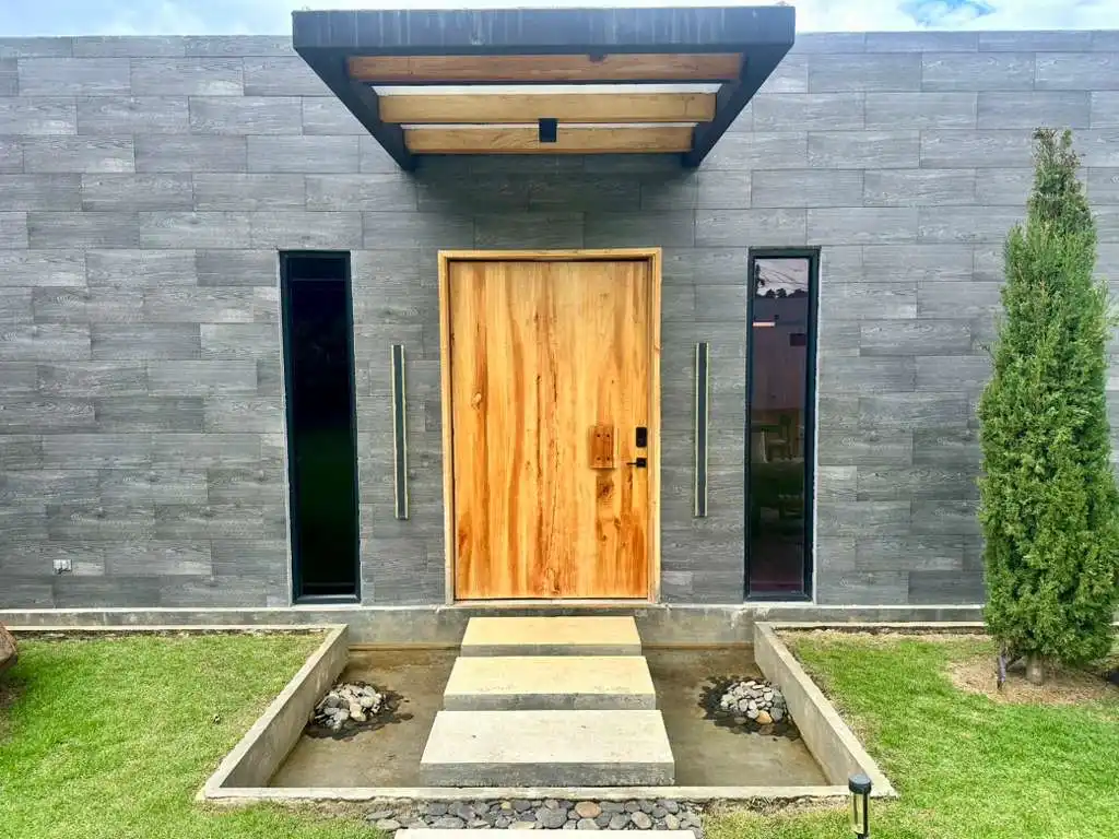 Finca campestre de lujo con diseño contemporáneo, entrada iluminada y jardín, ideal para relajarse cerca del Lago Calima.