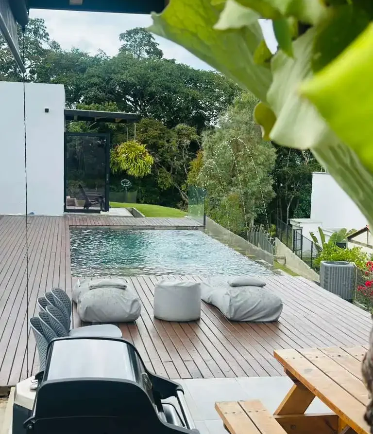 Casa campestre moderna en Lago Calima con piscina infinita, deck de madera y área de parrilla al aire libre.