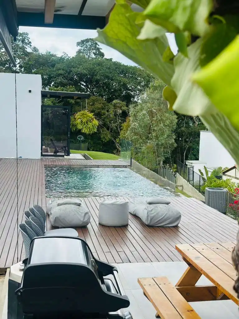 Casa campestre moderna en Lago Calima con piscina infinita, deck de madera y área de parrilla al aire libre.