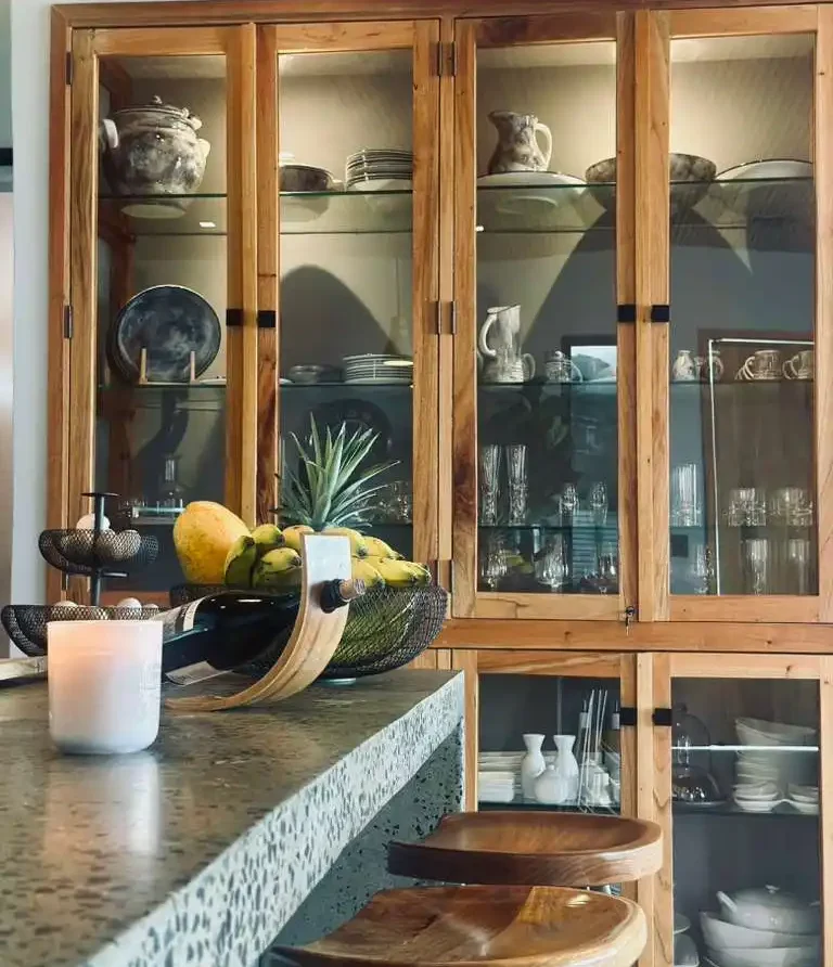 Hermosa cocina de casa campestre con barra, frutas frescas y vitrinas de madera, ideal para Lago Calima.