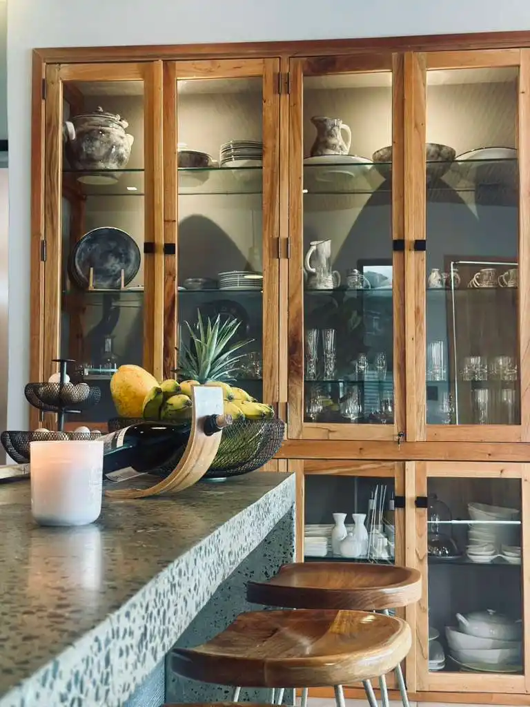 Hermosa cocina de casa campestre con barra, frutas frescas y vitrinas de madera, ideal para Lago Calima.
