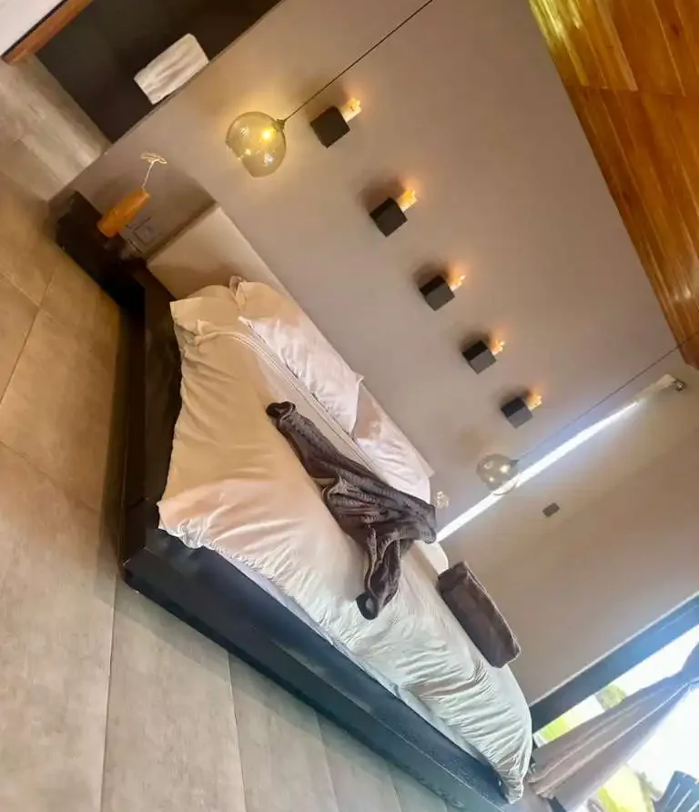 Dormitorio moderno en casa campestre, cama king-size y decoración elegante. Ambiente acogedor cerca de Lago Calima.