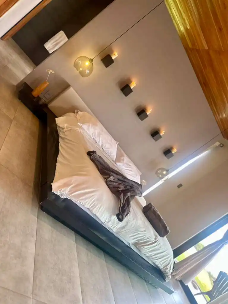 Dormitorio moderno en casa campestre, cama king-size y decoración elegante. Ambiente acogedor cerca de Lago Calima.