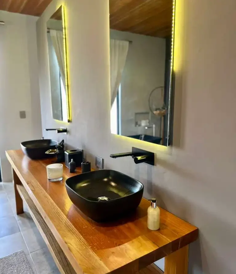 Doble lavabo moderno en madera y espejos iluminados, ideal para una hermosa casa campestre en Lago Calima.