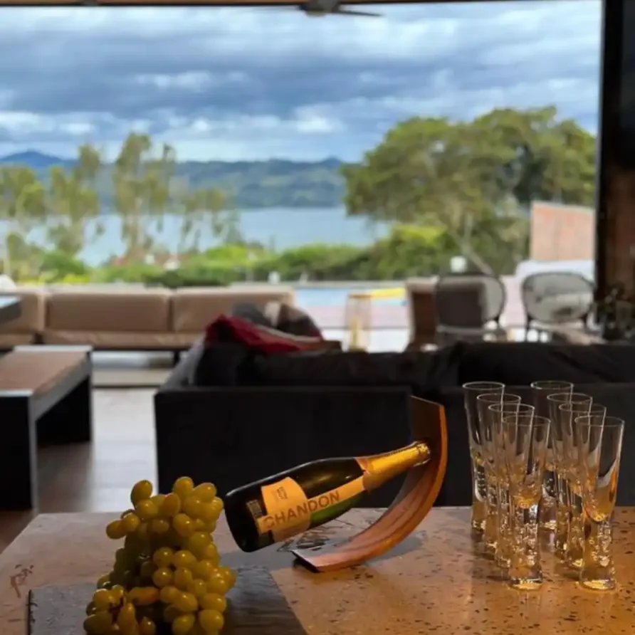 Botella de Chandon, uvas y copas en mesa de casa campestre con vista al Lago Calima.