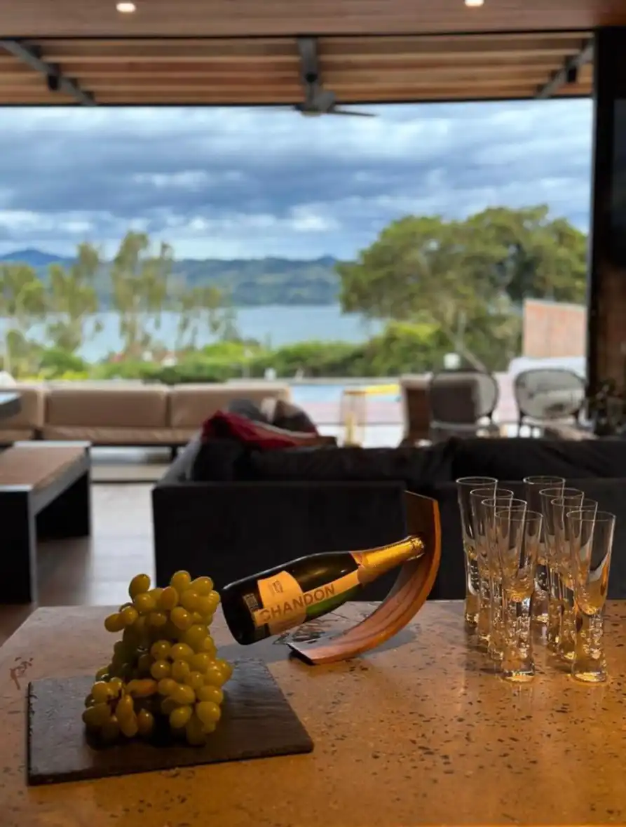 Botella de Chandon, uvas y copas en mesa de casa campestre con vista al Lago Calima.