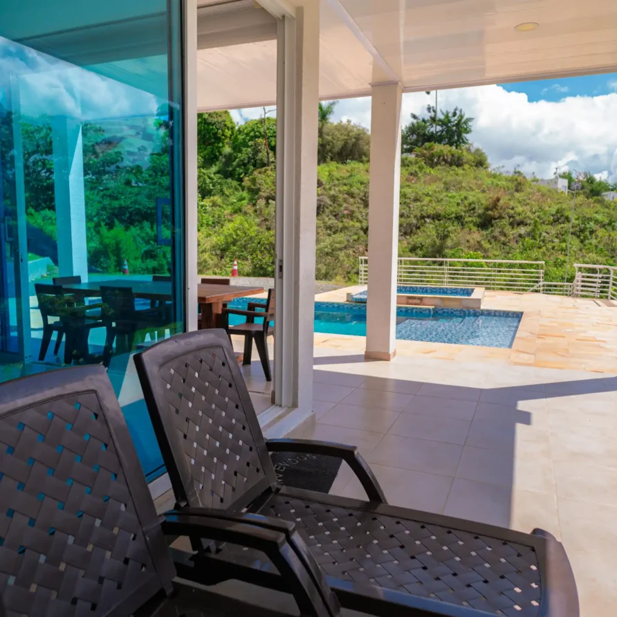 Exterior de cabaña con alberca de varios niveles y zona de comedor en patio con vista natural en Lago Calima.