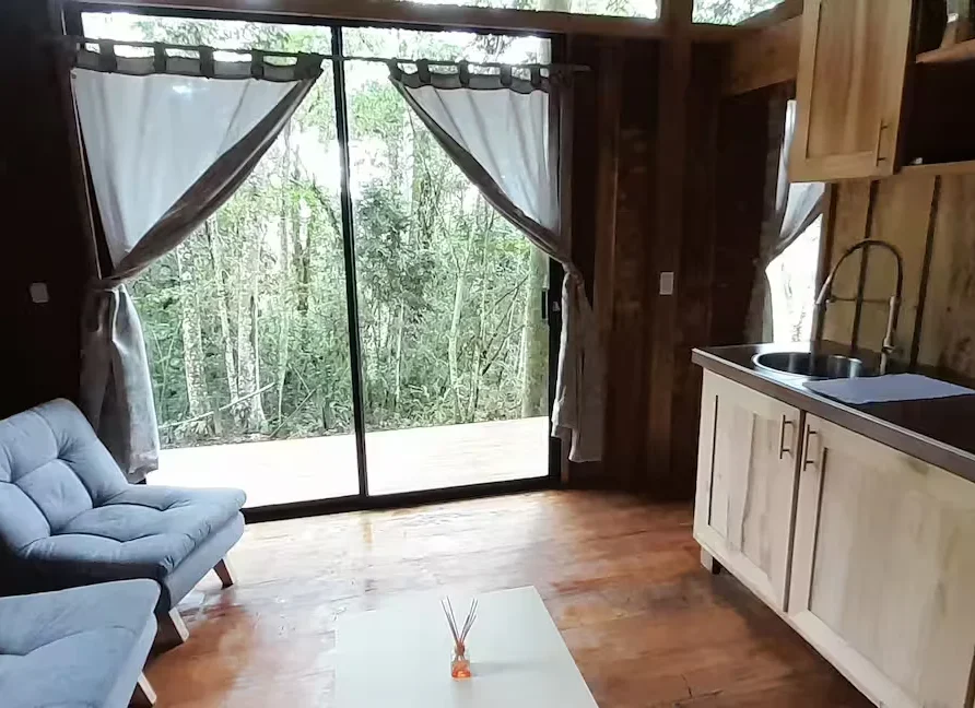 Planes Turisticos 119 Interior de cabaña de madera con cocina, sala, y gran ventanal al bosque. Ideal para pareja en Lago Calima.