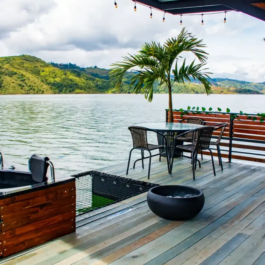 Espacio exterior de glamping en el Lago Calima, suroccidente de Colombia, con mesa, sillas, parrilla y hermoso paisaje.