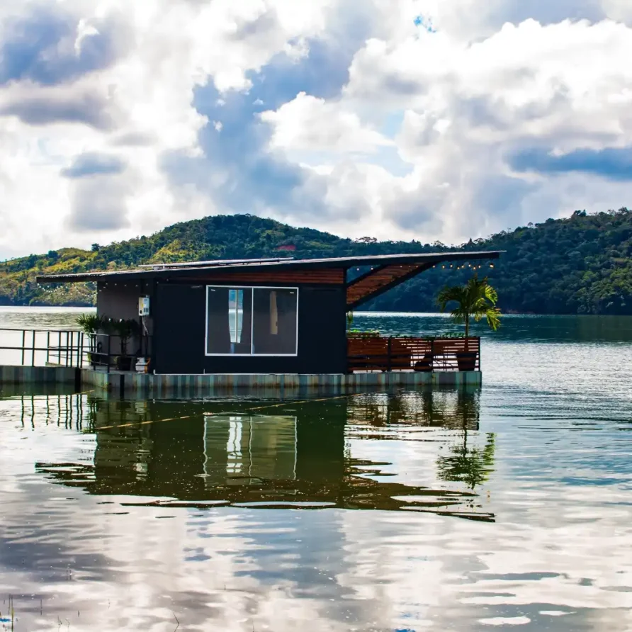 Cabaña flotante de glamping en Lago Calima, Calima El Darién, con terraza de madera y acceso por muelle.