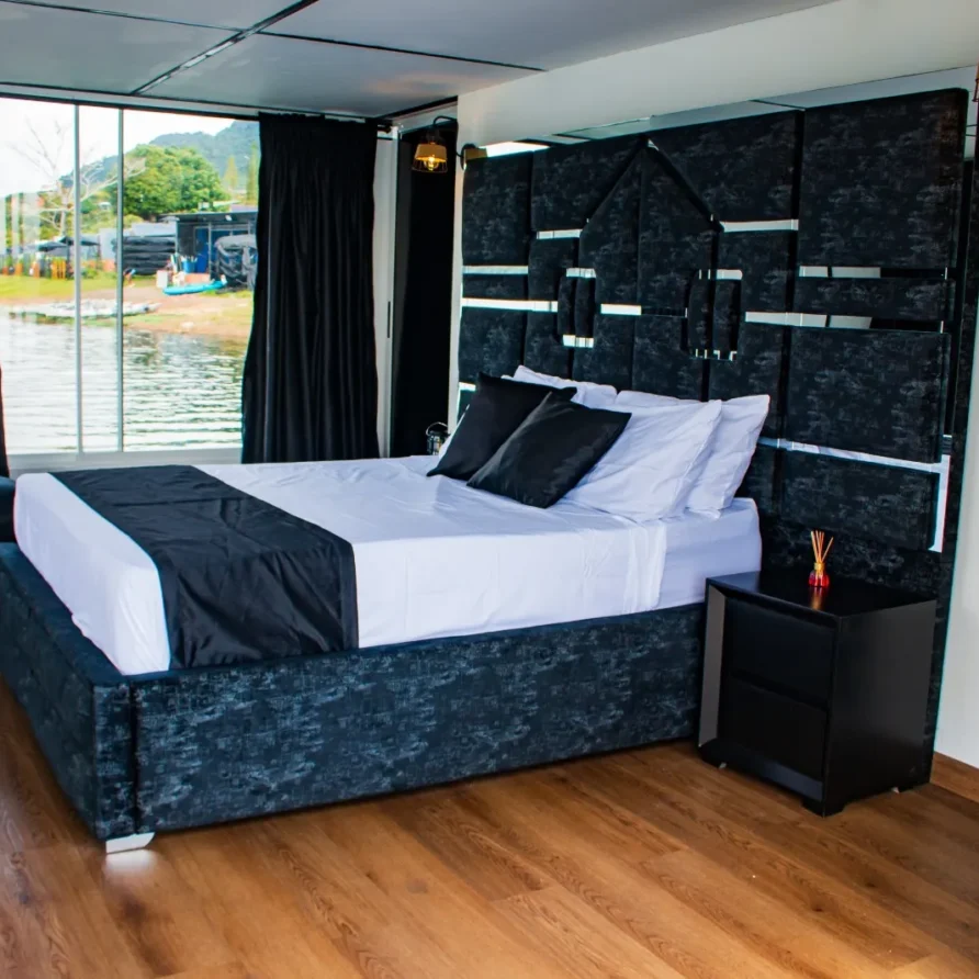 Habitación moderna de glamping flotante con cama king y vista al Lago Calima, Colombia.