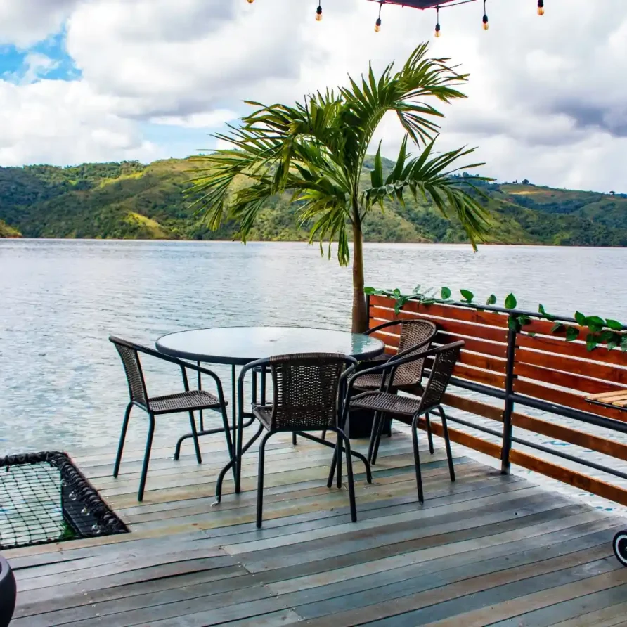 Espacio exterior de glamping en el Lago Calima, suroccidente de Colombia, con mesa, sillas, parrilla y hermoso paisaje.